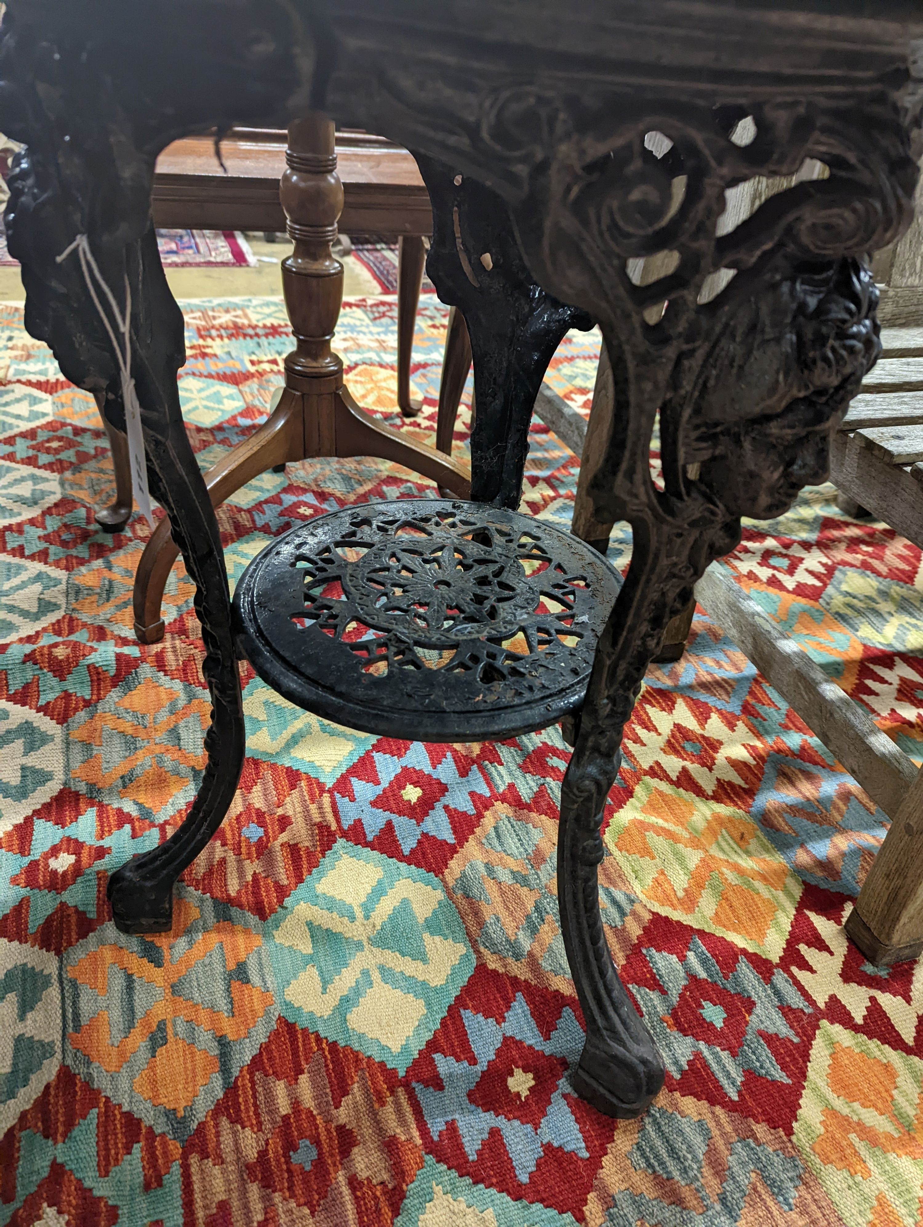 A Victorian cast iron Britannia table with circular weathered wood top, diameter 58cm, height 69cm